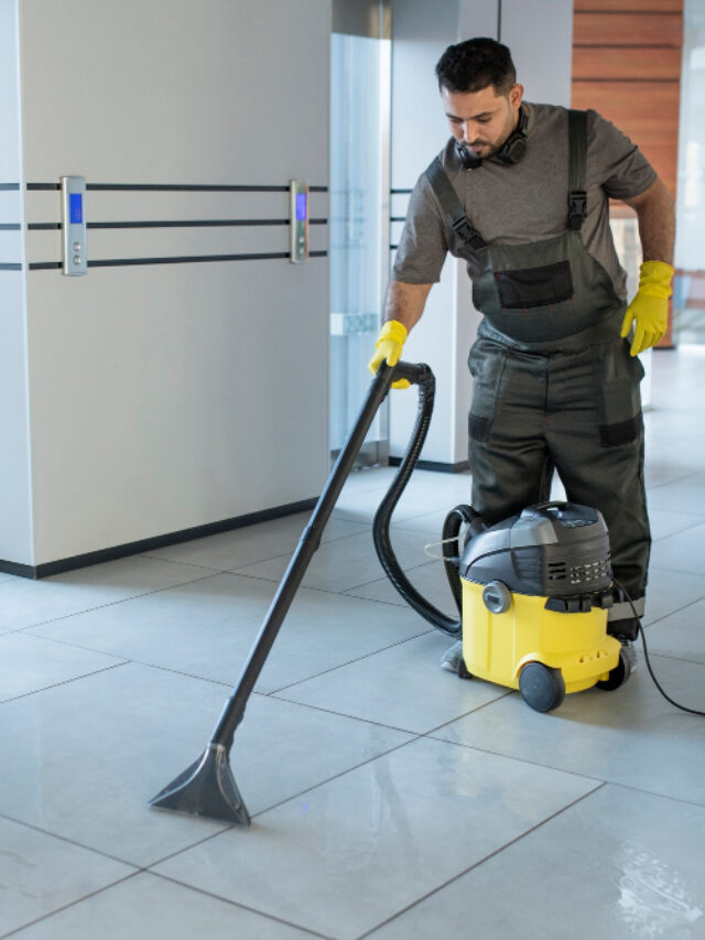 cropped full shot man vacuuming office floor
